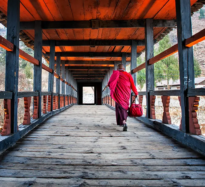 a monk walking on a bridge